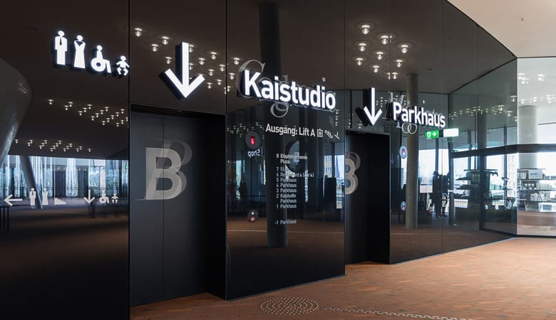 Leitsystemprojekt Elbphilharmonie, beleutete Einzelbuchstaben im Fahrstuhlbereich.