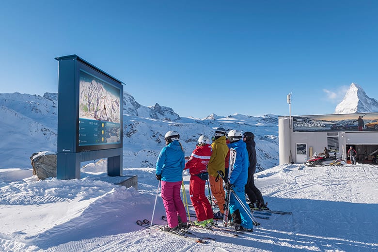 designage geo_Videowall im Skiegebiet Zermatt. Skifahrer verschaffen sich einen Überblick über das Skiegebiet